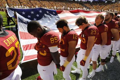 A minute of silence was held before the game in honor of Barquín. In this photo, members of the Cyclones team bow their heads as the Iowa State University band plays the national anthem.