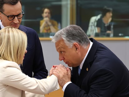 El primer ministro de Hungría, Viktor Orbán, saluda a su homóloga italiana, Giorgia Meloni, en presencia del jefe del Ejecutivo polaco, Mateusz Morawiecki, en la cumbre europea en Bruselas, el 29 de junio.