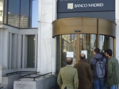 Varios clientes leen el comunicado del Banco de España en donde informa sobre el cierre del Banco Madrid, tras señalamientos de lavado de dinero de su matriz Banco Privado de Andorra. Elida Rodríguez