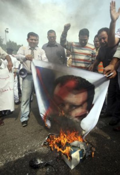 Manifestantes queman una pancarta con la fotografía del presidente sirio.