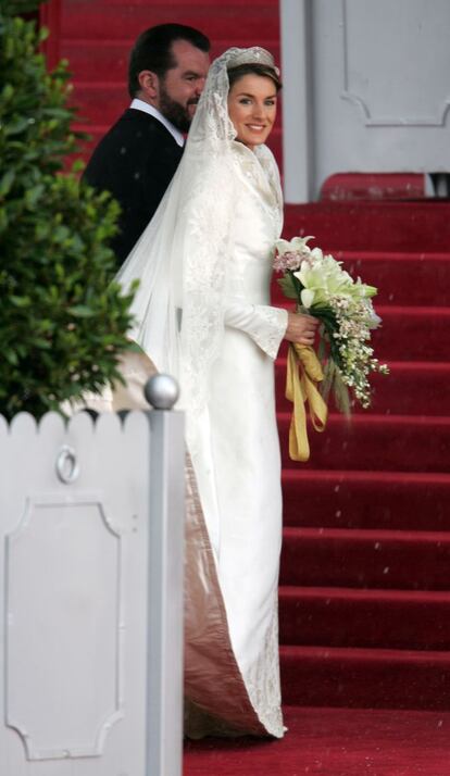 Boda del príncipe Felipe y Letizia Ortiz: la novia llega a la catedral de La Almudena, en Madrid, acompañada por su padre, Jesús Ortiz, con el traje diseñado por Pertegaz.