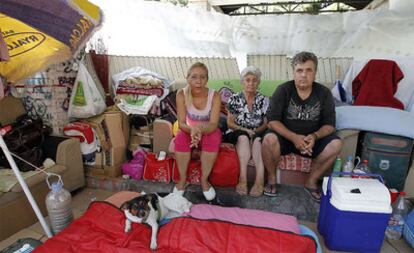 María del Carmen Bautista Ortiz, junto con sus dos hijos, en el chamizo que se ha construido en un parque del barrio madrileño de Orcasitas.