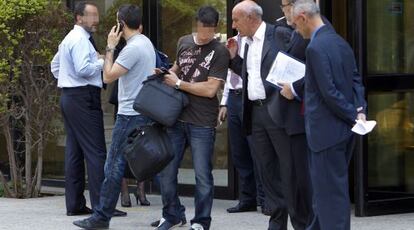 Agentes de la Policía y la comisión judicial salen de la Agencia Valenciana de Turismo tras el registro.