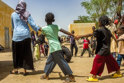 Children play with a caretaker at the Al Suwar displacement camp in Sudan on June 22, 2023.