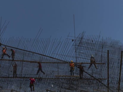 Operários do setor de construção trabalham em uma ponte rodoviária.