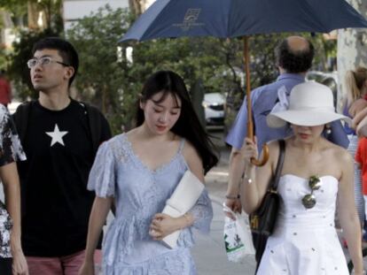 Unas turistas tratan de protegerse del sol en las cercanias del Museo del Prado en Madrid.