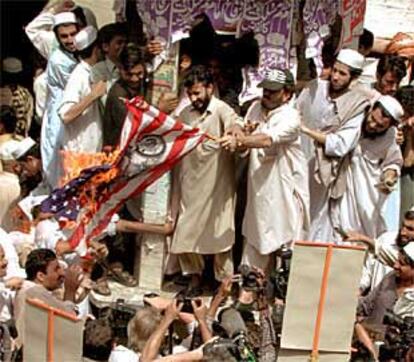 Un grupo de paquistaníes quema una bandera estadounidense en Peshawar (Pakistán).