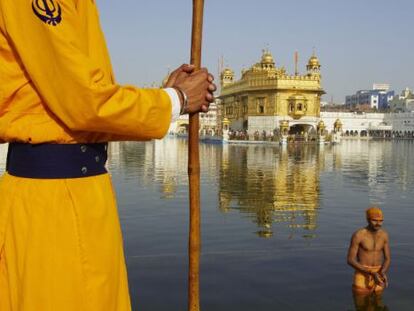 Un peregrino se ba&ntilde;a en el estaque que rodea el templo dorado de Amritsar, santuario sagrado para los sijs. 