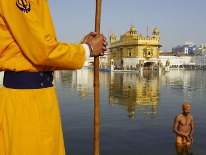 Un peregrino se ba&ntilde;a en el estaque que rodea el templo dorado de Amritsar, santuario sagrado para los sijs. 