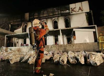 Los cadáveres de una docena de víctimas mortales yacen frente a la discoteca quemada en Bangkok.