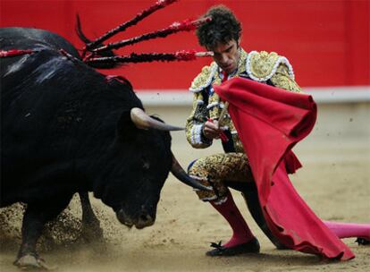 El torero José Tomás realiza un pase de muleta con la rodilla hincada en la arena de la Monumental de Barcelona.