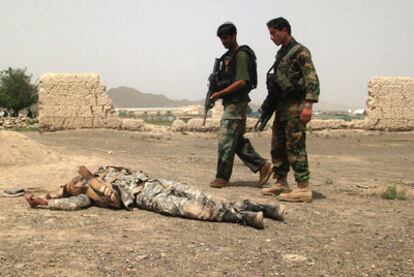 Dos soldados afganos junto al cadáver de uno de los asaltantes talibanes, en la provincia de Khost.