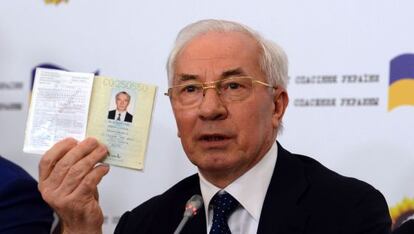 El ex primer ministro ucranio, Nikolái Azárov, sujeta un pasaporte durante una rueda de prensa este lunes en Moscú.