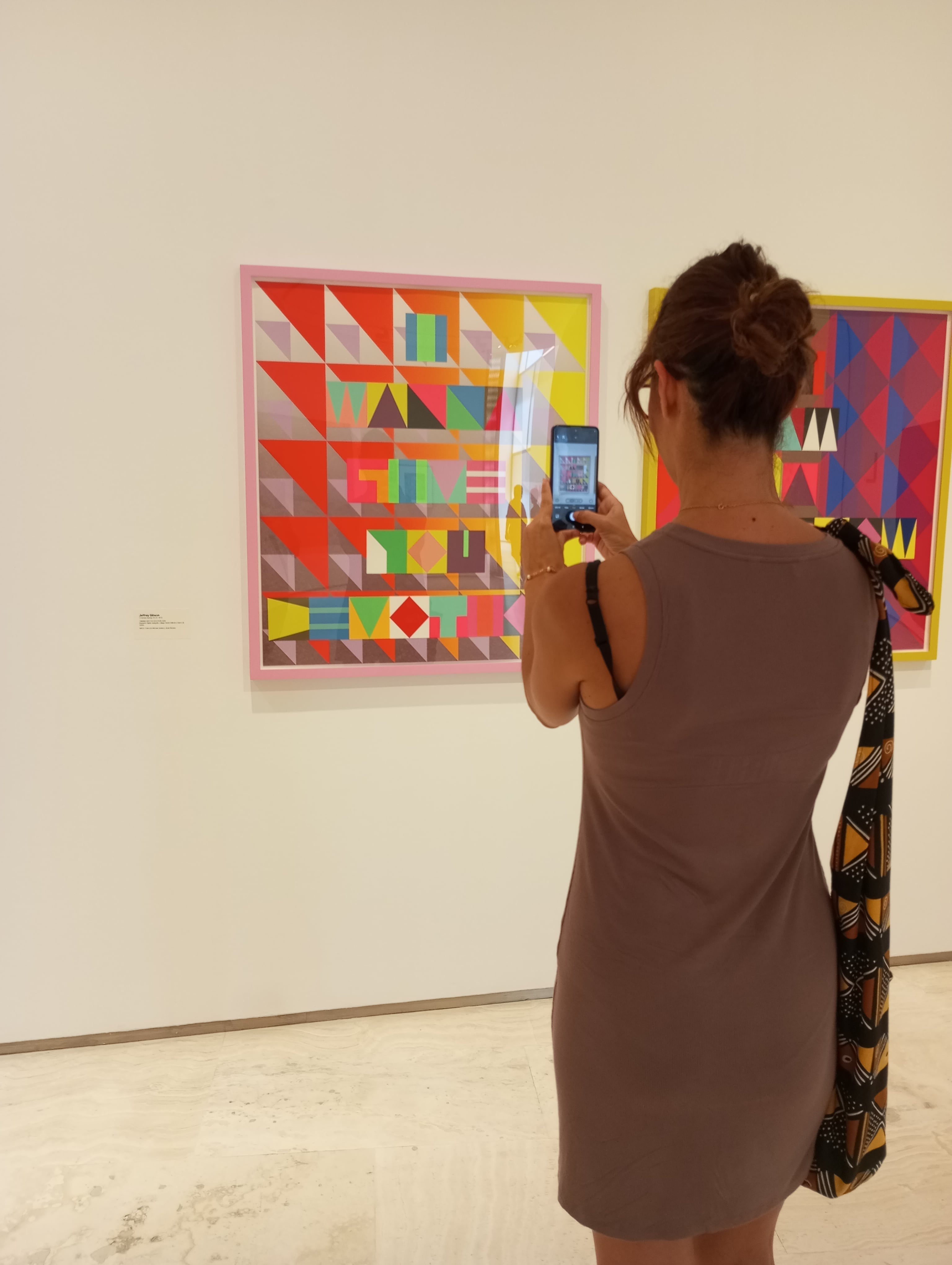 Una mujer hace una fotografía a un cuadro expuesto en la muestra 'Coloramas'.