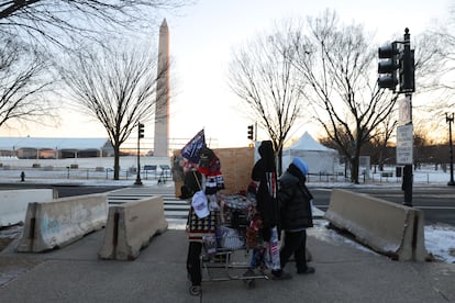 Un vendedor mercancías de apoyo a Donald Trump tira de un carrito, en las inmediaciones del Capitolio de Estados Unidos.