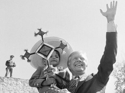 Jimmy Carter sostiene a un niño de ascendencia mexicana mientras saluda a simpatizantes en San Antonio, Texas, el 1 de noviembre de 1980.