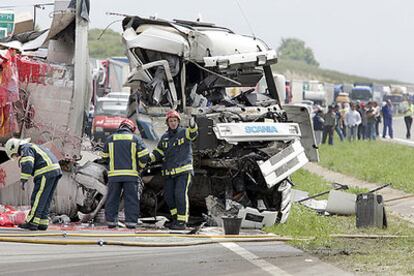 Varios bomberos intervienen para retirar de la calzada un camión que sufrió un grave accidente en la N-I el pasado mayo.