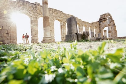 La larga sombra del norte de África romano atrapa al viajero en Volubilis, unas ruinas en medio de la suave campiña al norte del Atlas Medio, en un escenario soberbio. La historia sigue interpretando el paisaje aquí también; basta con desviar la mirada desde la prensa de aceitunas romana hasta el cercano Moulay Idriss, uno de los lugares de peregrinación más importantes de Marruecos y donde aún se produce uno de los mejores aceites de oliva del país. Volubilis es el monumento arqueológico mejor preservado de Marruecos, famoso y valioso sobre todo por sus espléndidos mosaicos perfectamente conservados y que representan animales, patrones intrincados y dioses romanos. Adornan lugares como la Casa de Orfeo, la más bonita y grande de todas, pero también la Casa del Acróbata, la del Efebo o la del Perro, que en su día fue un burdel para guerreros que descansaban en esta tranquila ciudad del norte africano. Pero hay muchas más casas, con nombres que aluden a la temática de sus mosaicos. Volubilis conserva también los restos de las termas, de la basílica, del capitolio, el foro o el arco de triunfo, que nos hablan de una ciudad que llegó a tener más de 20.000 habitantes en su época de esplendor en los siglos II y III.