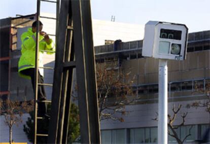 Un operario instala un radar fijo en la autovía de Castelldefels.