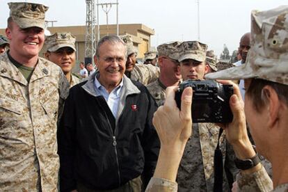 Un<i> marine </i>fotografía al secretario de Defensa, Donald Rumsfeld, durante su visita a la ciudad iraquí de Faluya.