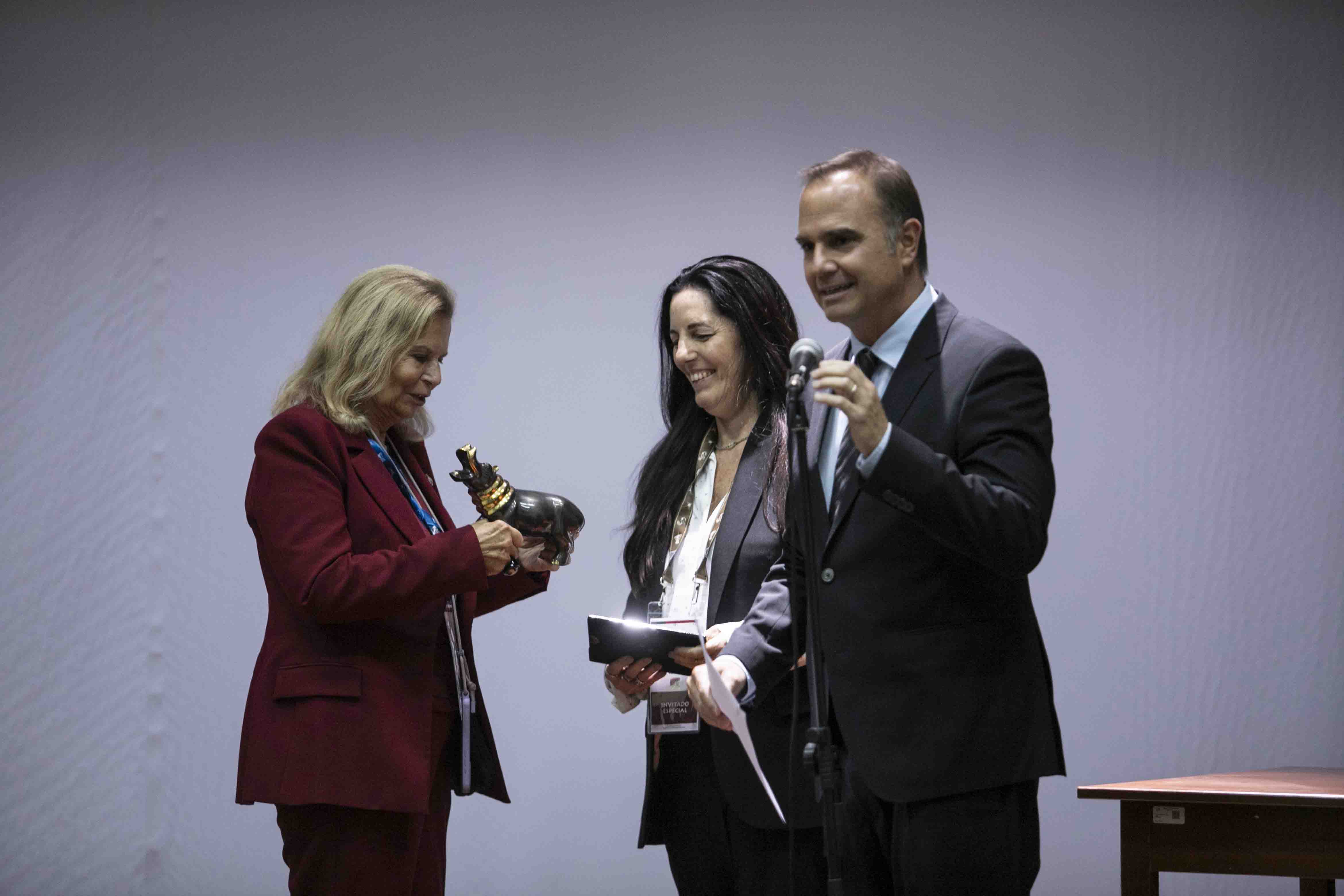 Carmen Riera, vicepresidenta la Real Academia Española, recibe de Morgana Vargas Llosa un hipopótamo de la colección de figuras del escritor junto al director del museo Raúl Tola.