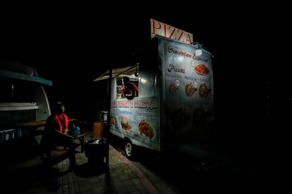 Un vendedor ilumina su negocio con bombillas alimentadas por un generador ante los apagones en Manta, Ecuador.