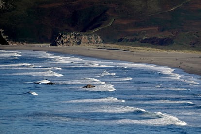 Grupos de personas pasean este miércoles día 1 por la playa de los Quebrantos (Asturias).