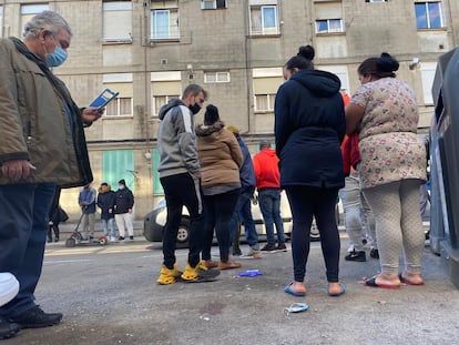 Varios vecinos sobre el lugar en el que ha sido abatido un hombre en Villaverde este viernes.