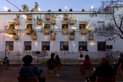 Los vecinos asisten al concierto 'Sinergias', una polifonía compuesta por Desirée Martín, ante el jardín vertical que forma parte del proyecto en Tres Barrios-Amate, Sevilla.