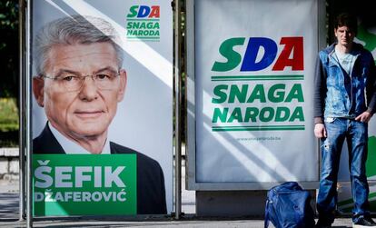 Un joven, junto a un cartel electoral en Sarajevo, el pasado 25 de septiembre.