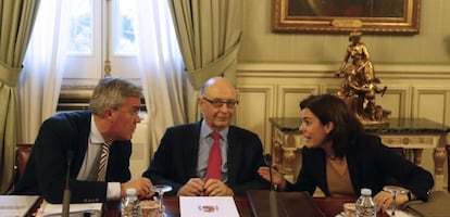 El ministro de Hacienda, Crist&oacute;bal Montoro, flanqueado por la vicepresidenta del Gobierno, Soraya S&aacute;enz de Santamar&iacute;a, y el secretario de Estado de Hacienda, Jos&eacute; Enrique Fern&aacute;ndez de Moya. efe