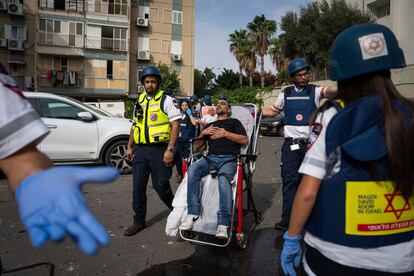 Paramédicos israelíes evacúan a un hombre herido, tras el impacto de un misil disparado desde Gaza, este viernes en Tel Aviv, Israel.