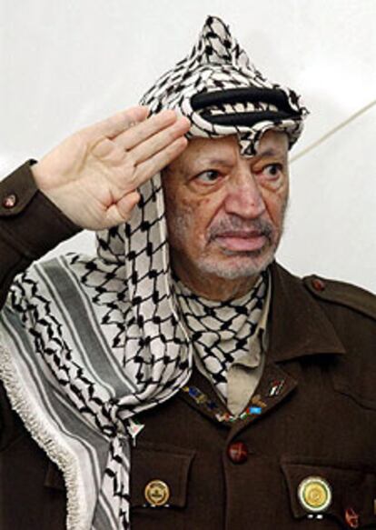 El líder palestino saluda mientras una banda toca el himno nacional, a finales de diciembre en su oficina de Ramala.