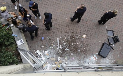 Agentes ante un local destrozado durante las protestas en Charlotte