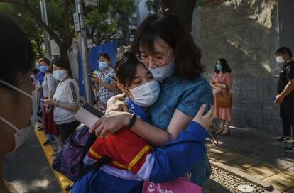 Una estudiante china abraza a su madre antes de entrar a una escuela para realizar el examen nacional de ingreso a la universidad en una escuela secundaria esta mañana en Pekín.