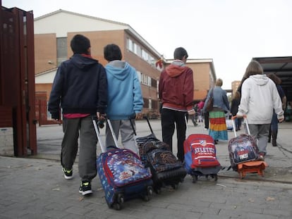 Varios niños entran en el colegio público La Latina en Aluche.