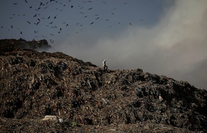 Un hombre camina sobre basura en un vertedero de Nueva Delhi (India), el 28 de marzo.