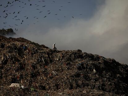 Un hombre camina sobre basura en un vertedero de Nueva Delhi (India), el 28 de marzo.