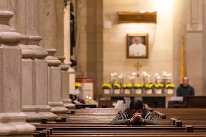 Un hombre reza frente a una fotografía del Papa en la catedral de St. Patrick, este lunes en Nueva York.