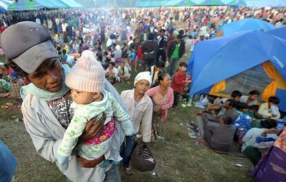 Un hombre birmano lleva a su hijo en brazos en el campamento de refugiados situado en una base de la policía en la localidad fronteriza de Mae, en Tailandia.