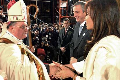 El obispo Juan Carlos Maccarone saluda a Cristina Kirchner en presencia de su esposo en mayo pasado.