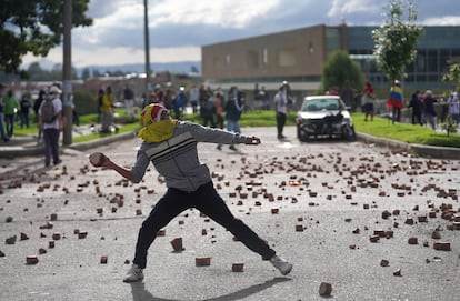 Un manifestante lanza una piedra durante las protestas en Bogotá