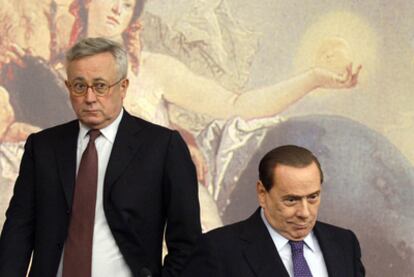 El primer ministro italiano, Silvio Berlusconi, sentado, junto al titular de Economía, Giulio Tremonti, el pasado viernes.