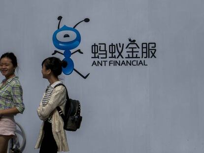 Dos jóvenes pasan junto al logo de Ant Financial, del grupo Alibaba.