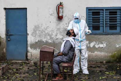 Un sanitario realiza una prueba PCR en la ciudad de Nueva Delhi (India). El país ha registrado este domingo un nuevo récord de contagios de coronavirus, con al menos 90.632 en 24 horas, y se acerca ya a las cifras globales de Brasil, el segundo país con mayor número de casos de la covid-19 en todo el mundo, solo por detrás de Estados Unidos.