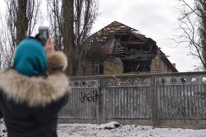 Una mujer saca un fotografía del edificio gubernamental dañado por los ataques de drones rusos esta mañana en Kiev.