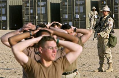 Una <i>marine</i> de EE UU vigila a un grupo de falsos prisioneros de guerra durante un ejercicio a 32 kilómetros de la frontera de Irak.