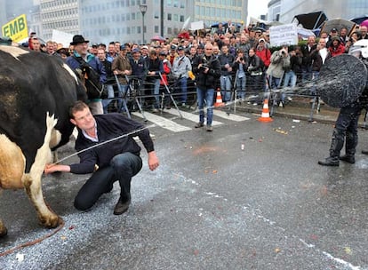 Un ganadero rocía con leche a un policía durante las protestas a las puertas de la Comisión Europea.