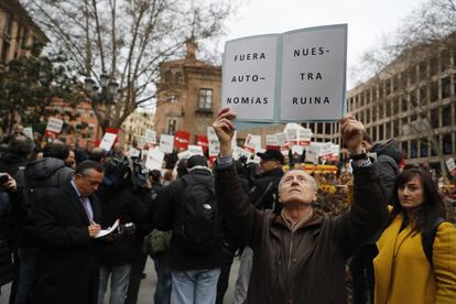 Un home amb un cartell contra les autonomies a la plaça del Rey de Madrid.