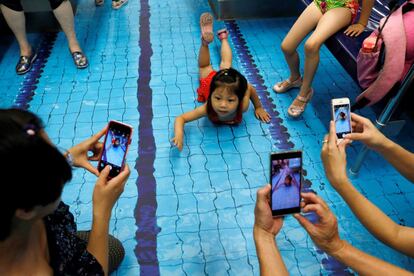 Una niña posa mientras es fotografiada en el una vagón de metro decorado con temática deportiva, en Taipei, Taiwan.